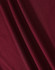 A close-up of a textured fabric in a rich burgundy colour, showcasing its drape and weave.