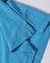 A close-up of a turquoise polo shirt, featuring a branded label and detailed fabric texture.
