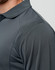 A close-up of a dark grey long-sleeve polo shirt featuring textured fabric and a collar. It has a logo on the chest area.