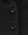 A close-up of a black polo shirt featuring buttons and a subtle texture, highlighting its sustainable fabric.