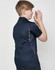 A navy blue kids' polo shirt featuring short sleeves and contrast detailing. The shirt includes a logo.