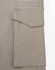 A close-up of a beige work pant pocket featuring a flap, showcasing the fabric texture and stitching detail.