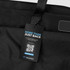 A black duffle bag with a handle and a tag featuring a QR code and branding.