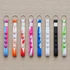 A selection of eight popper stress reliever key chains in various bright colours, featuring multiple buttons for popping.