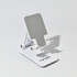 A white folding desktop mobile phone and tablet stand with a textured grey surface. It features a logo on the base.