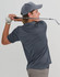 A model swings a golf club while wearing a grey sustainable jacquard knit short-sleeve polo shirt and a cap.