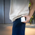 A magnetic wireless power bank in white is being placed in a pocket by a person wearing a light top and dark pants.
