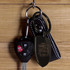 A black key ring attached to a car key fob, with a branded logo and leather tag.
