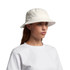 A white bucket hat is featured, made of soft fabric with a brim and eyelet vents, worn by a model.