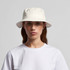 A white bucket hat with a soft brim, featuring a logo, worn by a model in a plain white T-shirt.