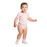A pink organic infant one-piece with short sleeves, featuring a snug fit and paired with light pink socks.