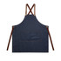 A denim apron with brown leather straps and a front pocket, featuring a logo.
