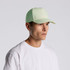 A light green nylon cap worn by a person, featuring a structured design and a logo on the front.