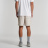 Relax Track Shorts in light beige, featuring a back pocket and a logo. Model wearing shorts with a white t-shirt.