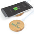 A bamboo wireless charger in a circular shape with a logo, next to a smartphone displaying a charging battery icon.