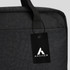A black laptop bag featuring a top handle and a tag with a logo. The material has a textured finish.
