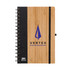 A spiral-bound notebook with a wooden bamboo cover and a black spine, featuring a logo on the front.