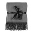 A grey herringbone throw blanket wrapped with a black ribbon and tag, featuring fringed edges.