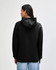 A black unisex hooded sweatshirt from American Apparel, viewed from the back. It has a relaxed fit and a hood.