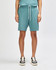 Unisex gym shorts in a soft teal colour, featuring an elastic waistband and pockets, paired with white sneakers.