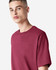 A maroon American Apparel Super Heavyweight T-Shirt displayed on a model with short hair and a neutral background.