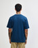 A blue American Apparel Super Heavyweight T-Shirt viewed from the back, with a simple design and a logo.