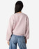 A women's crewneck sweatshirt in soft pink, featuring a relaxed fit and a branded label on the back.