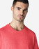 A light cotton T-shirt in vibrant red, modelled by a man with short dark hair and a neutral expression.