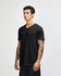 A black unisex V-neck T-shirt displayed on a model standing sideways, featuring a logo.