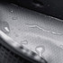 A grey interior of a cooler bag features a textured surface with visible water droplets. It has a logo.