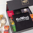 A gift pack featuring assorted gourmet treats, a black branded tote bag, and colourful packaging.