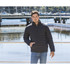 A unisex black puffer jacket with a zip front and side pockets, modelled by a man beside a waterfront.