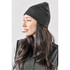 A dark grey knit beanie worn by a woman with long hair, featuring a simple design and a fitted shape.