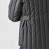 A thermal jacket in dark grey with quilted texture and button detail on the sleeve. It features a relaxed fit.