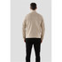 A beige Men's Avalante 1/4 zip pullover is displayed from the back, featuring long sleeves and a simple design.
