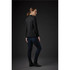 A black women's knit blazer, styled with dark jeans, displayed from the side against a dark background.