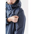 A navy blue men's jacket features a hood and multiple pockets, including an arm pocket. It has a logo.