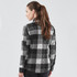 A women's shacket in a black and grey checkered pattern, featuring a quilted design and a collar.