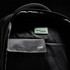 An interior view of a black backpack featuring compartments, a logo, and RFID protection detailing.