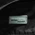 A close-up of the interior of a black duffle bag featuring a branded logo tag.