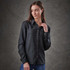 A woman models a long-sleeve, button-up shirt in dark grey, featuring a front pocket and a subtle logo.