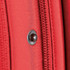 A close-up of a red fabric detail featuring a zipper and a decorative snap button, showcasing the material texture.