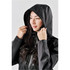 A woman wearing a black lightweight rain jacket with a hood and a logo on the sleeve.