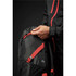 A green and black backpack with red accents, featuring a zippered pocket and a person adjusting the zipper.