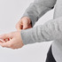 A grey 1/4 zip pullover with long sleeves, featuring wrist cuffs, held by a person.