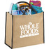 A large jute tote in brown with black handles, filled with a drink bottle, magazines, sunglasses, and a beach towel.