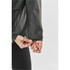 A green women's technical shell jacket, featuring a close-up of the cuff detail and logo on the sleeve.