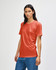A model wears an American Apparel Tri-Blend T-Shirt in a shade of rust, paired with denim jeans.