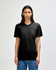 A black American Apparel tri-blend t-shirt worn by a model, featuring a simple design and a relaxed fit.