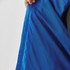 A close-up of the interior lining of a blue rain jacket, showing a textured fabric and a hands holding the jacket.